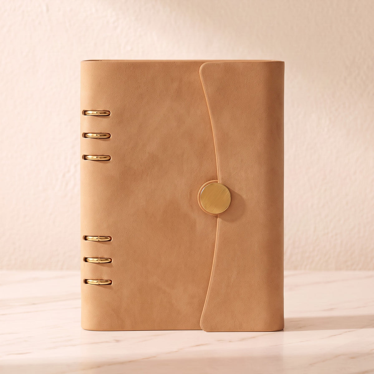 Front view of The Champagne A5 planner binder with gold 6-ring hardware and magnetic closure