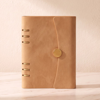 Front view of The Champagne A5 planner binder with gold 6-ring hardware and magnetic closure