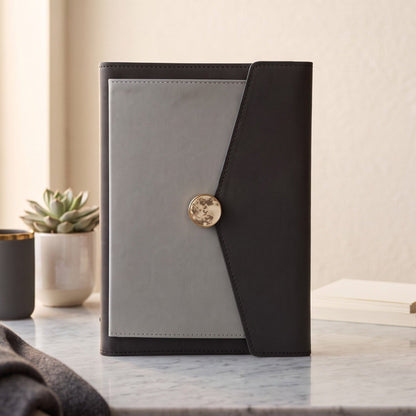 A closed A5 PU leather planner binder in charcoal and light grey with a marble-and-gold magnetic clasp.