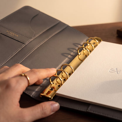 Close-up of the Noir Binder's 20mm gold six-ring mechanism.